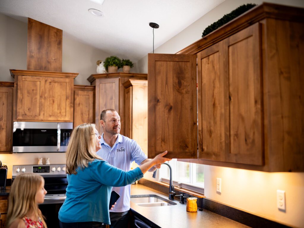 Woman and man looking at new cabinets in HiLine Homes Model Home of Salem.